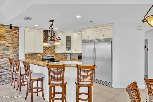 a kitchen with a stove a refrigerator and a dining table