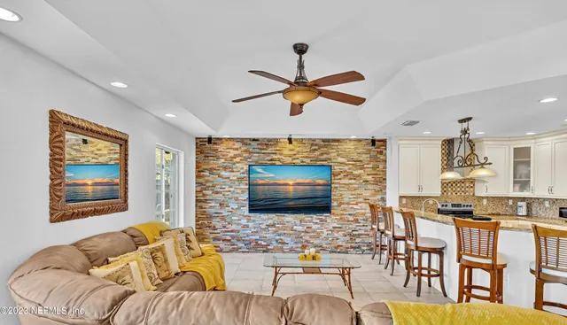 a living room with furniture ceiling fan and a window