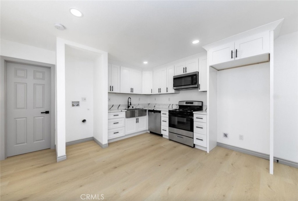 10 1/2 West Trafford Street Long Beach, CA 90805 - Photo 5 of 6 a kitchen with granite countertop a refrigerator and a stove top oven