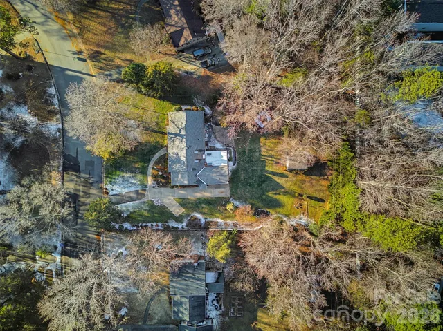 an aerial view of residential houses with outdoor space and trees