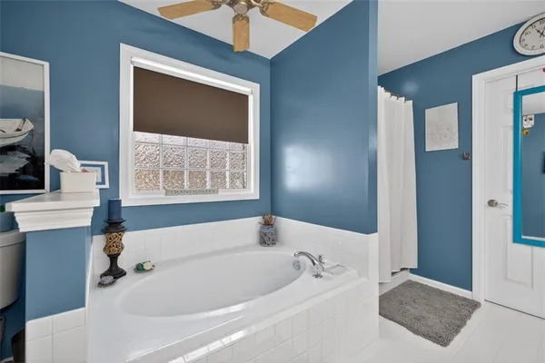 a bathroom with a tub sink and a mirror