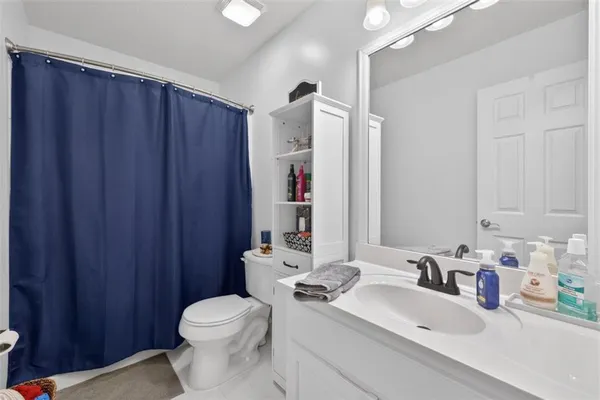 a bathroom with a sink a toilet and shower curtain