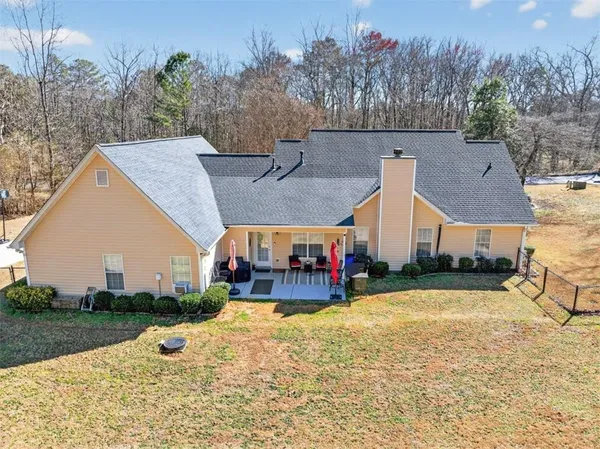 an aerial view of a house with a yard and basket ball court