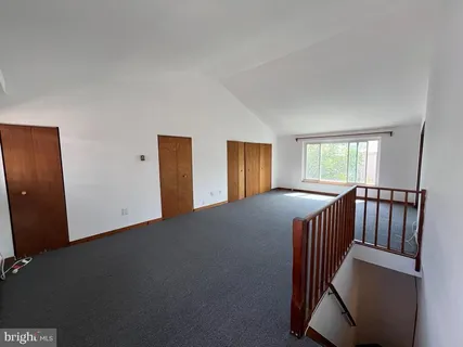 a view of a bedroom with wooden floor and windows