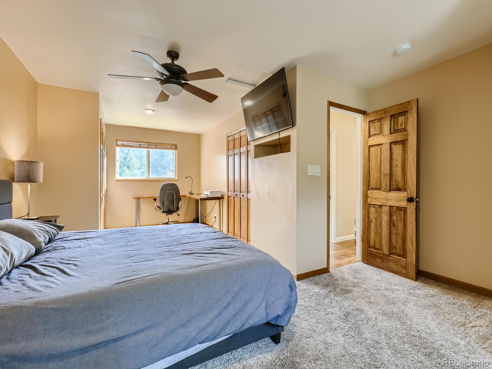 24697 Red Cloud Drive Conifer, CO 80433 - Photo 13 of 28 a bedroom with a bed and a chandelier