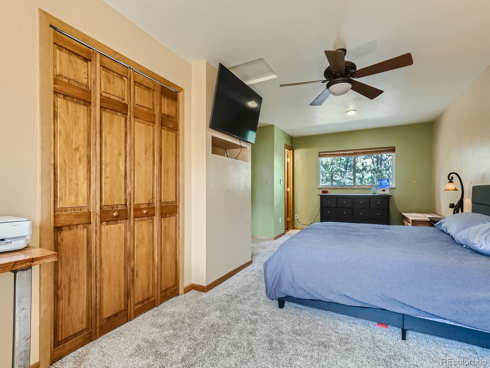 24697 Red Cloud Drive Conifer, CO 80433 - Photo 14 of 28 a bedroom with a large bed and a chandelier