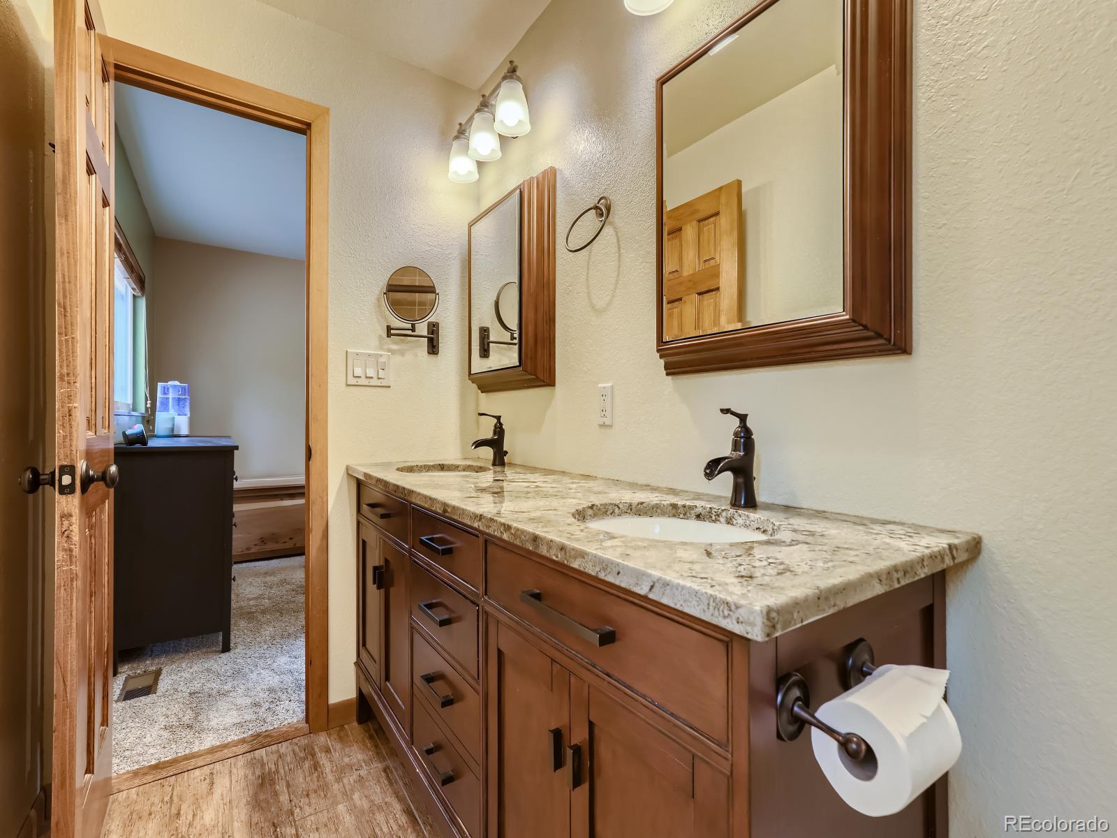24697 Red Cloud Drive Conifer, CO 80433 - Photo 15 of 28 a bathroom with a granite countertop sink and a mirror
