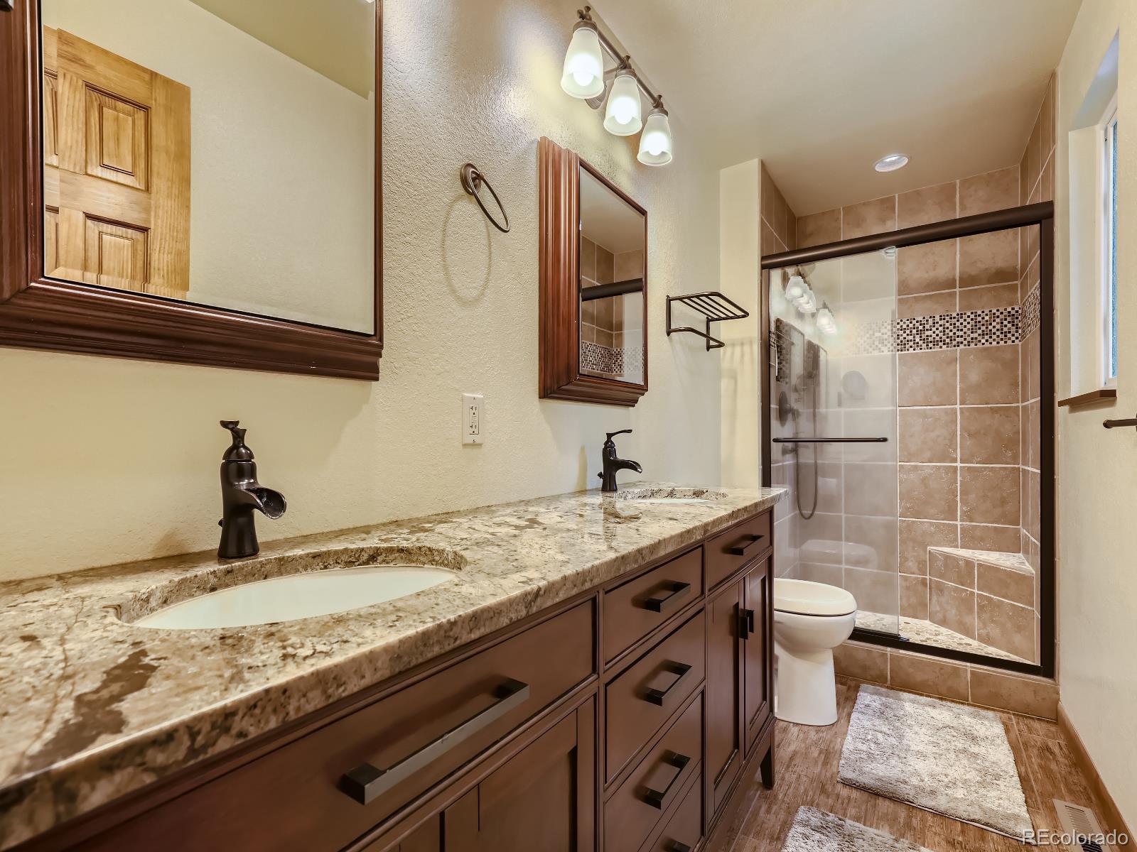 24697 Red Cloud Drive Conifer, CO 80433 - Photo 16 of 28 a bathroom with a granite countertop sink toilet and shower