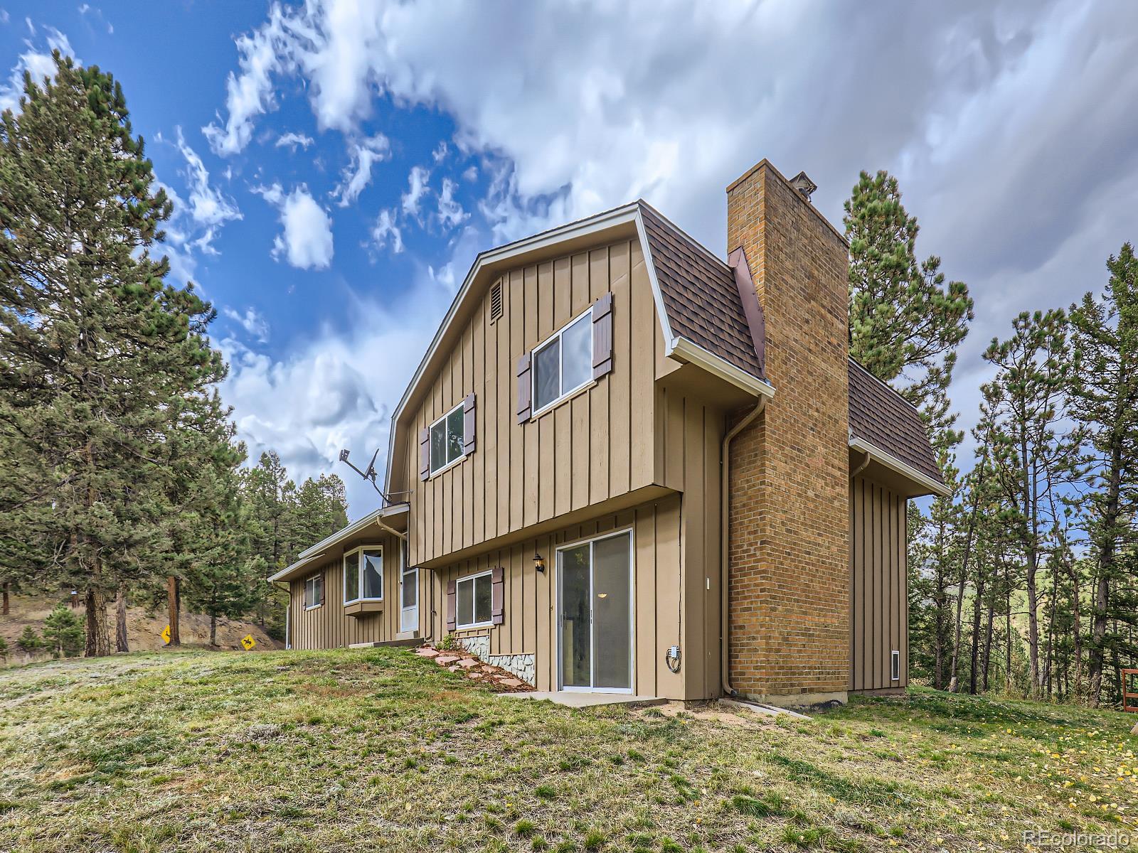 24697 Red Cloud Drive Conifer, CO 80433 - Photo 3 of 28 a front view of a house with garden