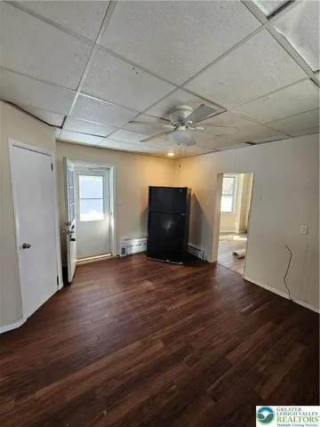 a view of empty room with wooden floor and window