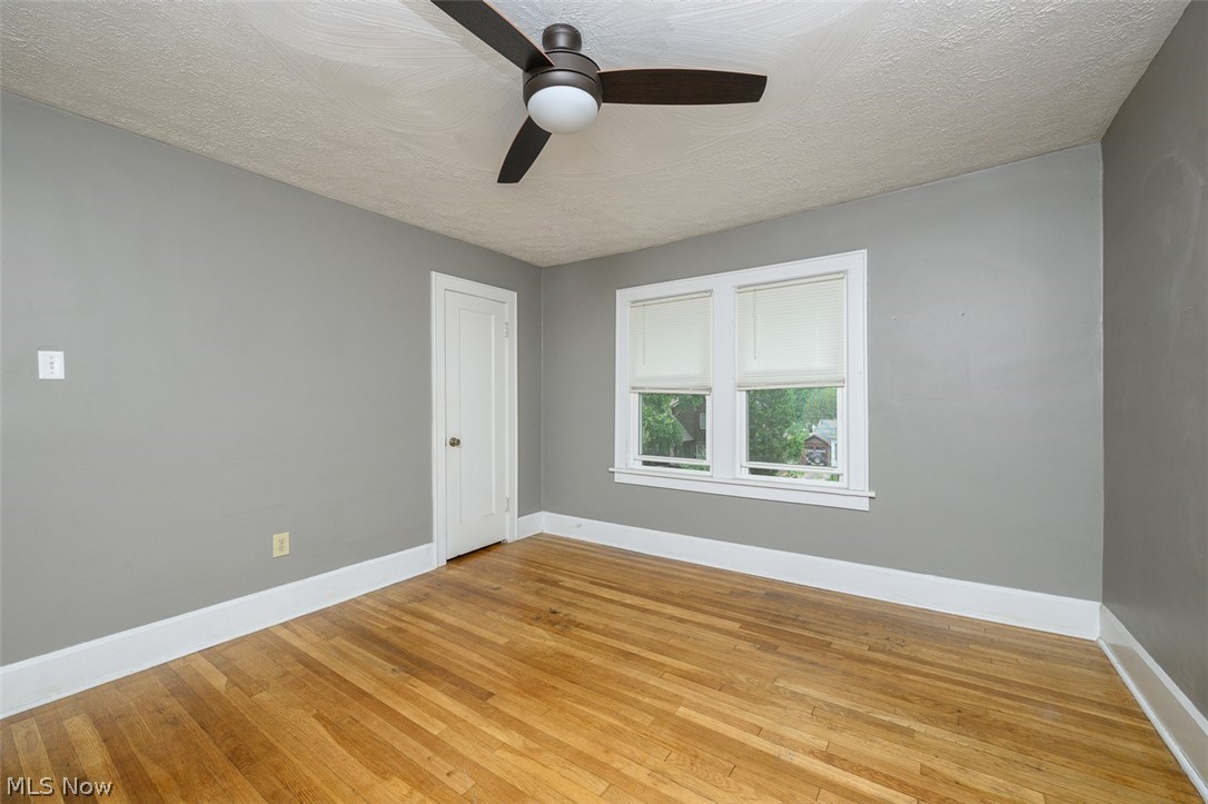 1222 Ridge Road Northwest Canton, OH 44703 - Photo 17 of 32 Upstairs bedroom with multiple windows, ceiling fan and wood flooring