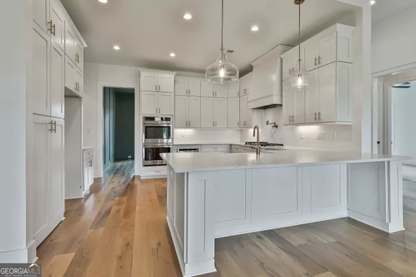 a kitchen with white cabinets and appliances