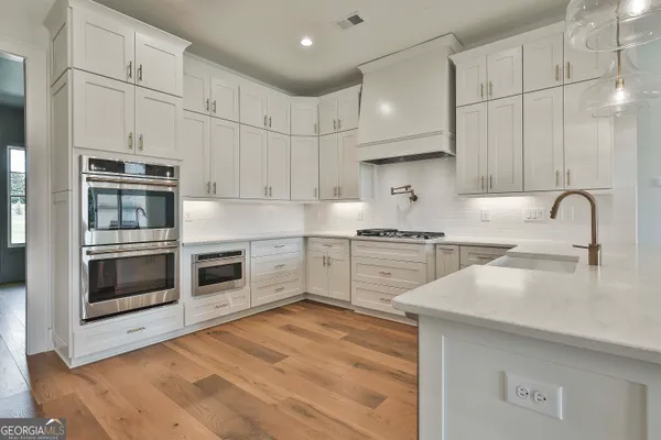 a kitchen with white cabinets and white appliances