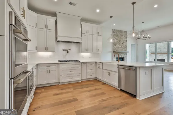 a kitchen with white cabinets and window
