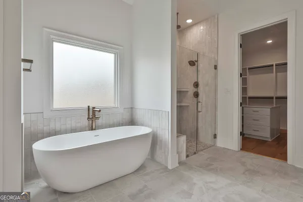 a spacious bathroom with a bathtub and shower