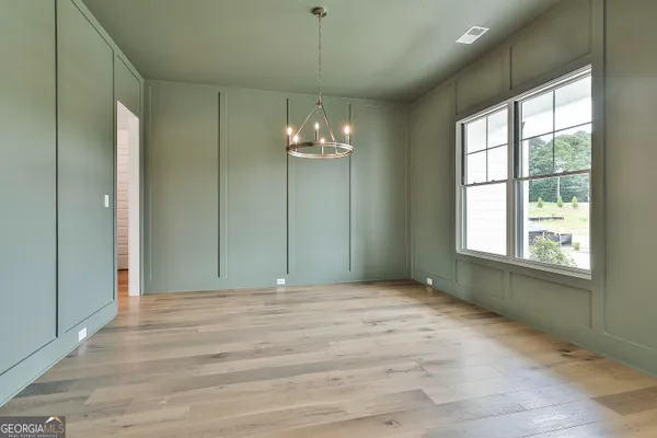 a view of a livingroom with a chandelier fan and windows