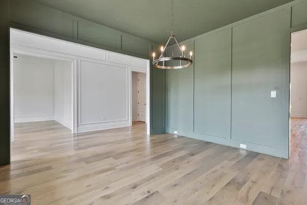 a view of a hallway with wooden floor and closet area