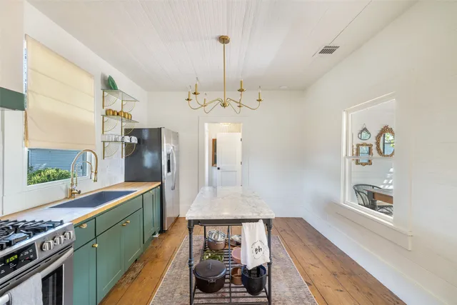 a kitchen with stainless steel appliances granite countertop a stove refrigerator and cabinets