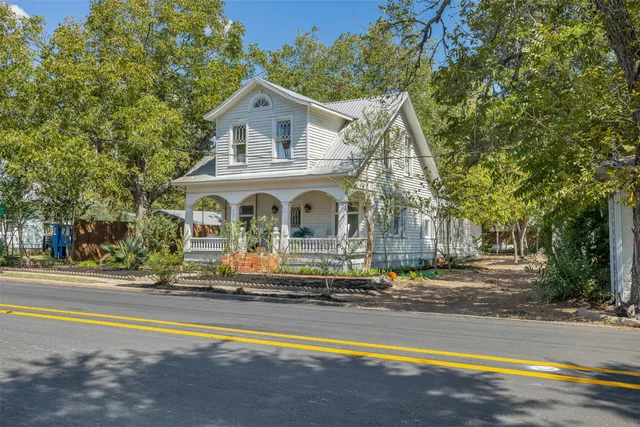 a view of a house with swimming pool and a yard with trees