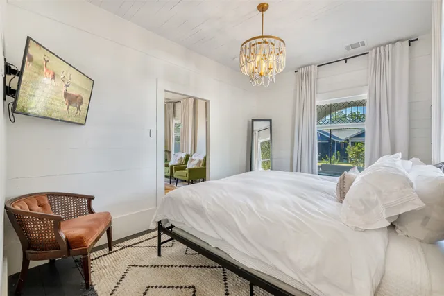 a bedroom with a bed and a chandelier