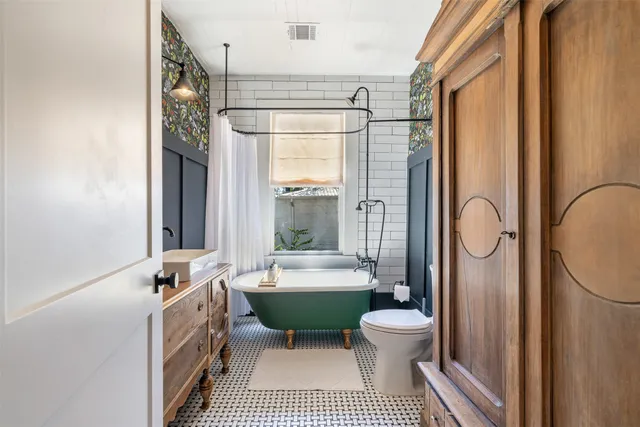a bathroom with a granite countertop sink a toilet and shower