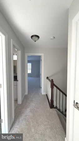 a view of a hallway with a livingroom and stairs