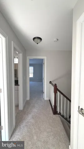 a view of a hallway with a livingroom and stairs