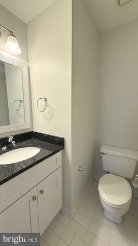 a bathroom with a granite countertop toilet sink and mirror