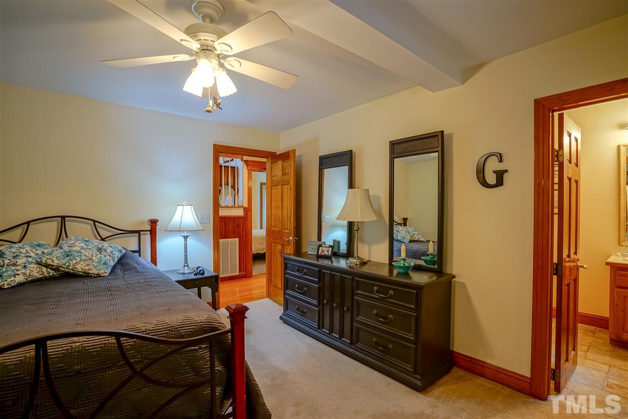 1032 Ridge Drive Clayton, NC 27520 - Photo 19 of 25 a bedroom with a bed a lamp and a dresser