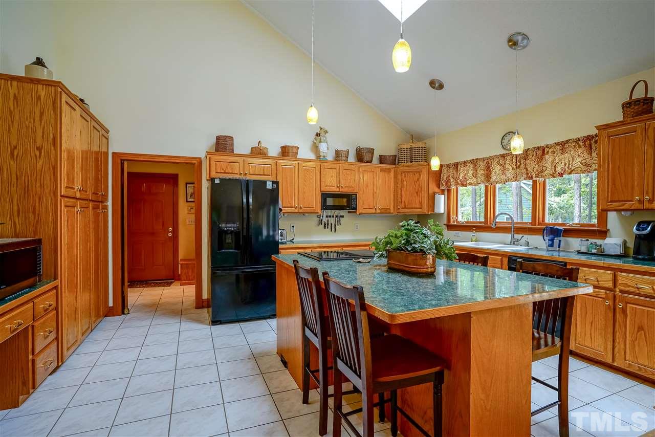 1032 Ridge Drive Clayton, NC 27520 - Photo 5 of 25 a kitchen with stainless steel appliances granite countertop a refrigerator a stove and a sink with wooden cabinets