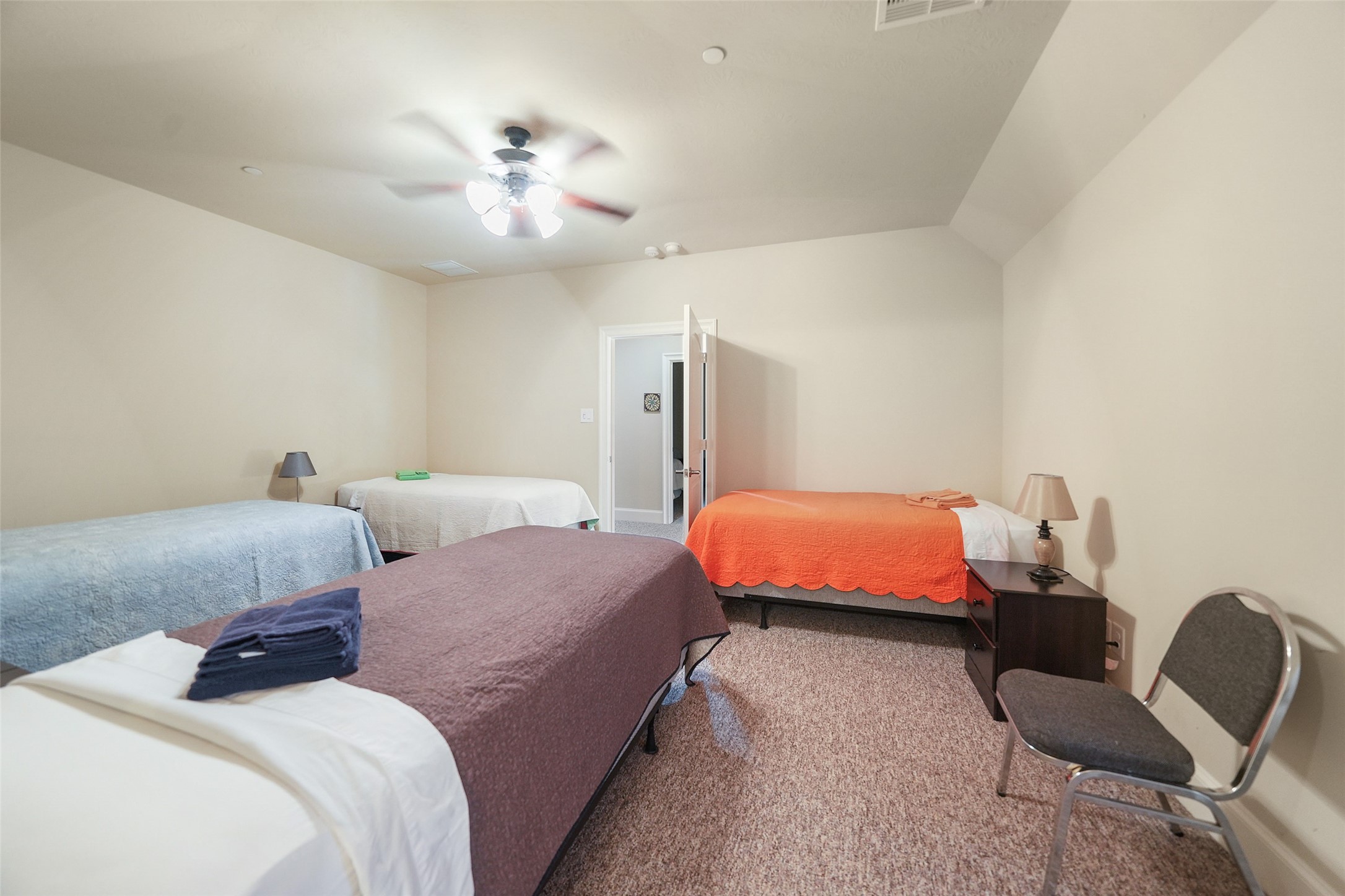 26250 B Riley Road Waller, TX 77484 - Photo 24 of 45 Upstairs bedroom arranged for multi-bed lodging, featuring neutral walls, carpeted flooring, and convenient access to an adjoining full bathroom.