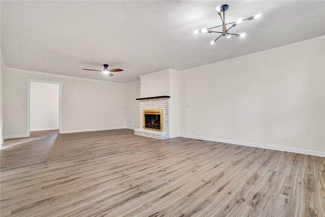 237 Earle Road Central, SC 29630 - Photo 9 of 24 A spacious living area with resilient wood flooring and a classic brick fireplace.