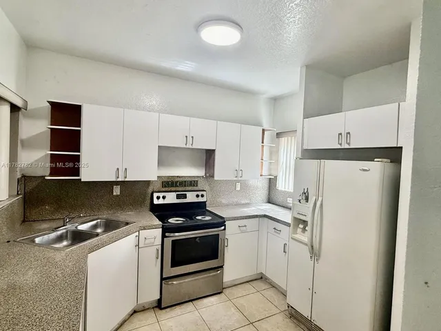 a kitchen with white cabinets and white appliances
