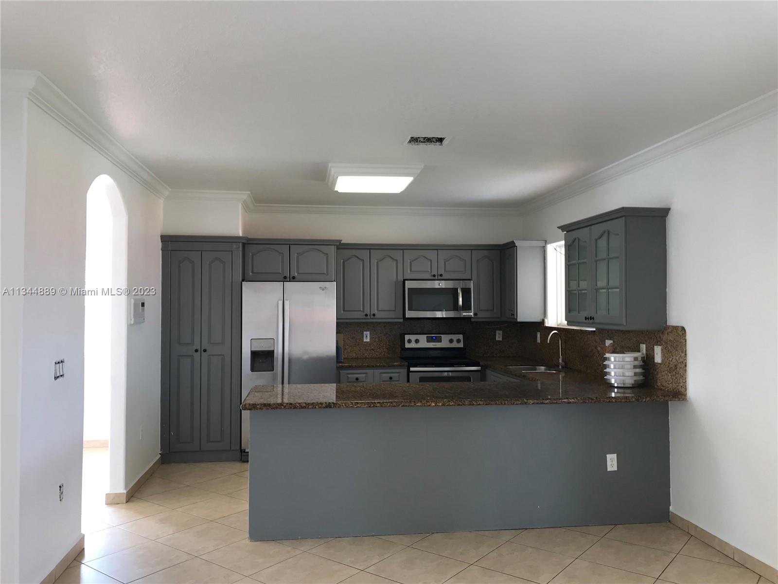 16057 Southwest 53rd Terrace Miami, FL 33185 - Photo 11 of 30 a kitchen with stainless steel appliances a refrigerator and a stove