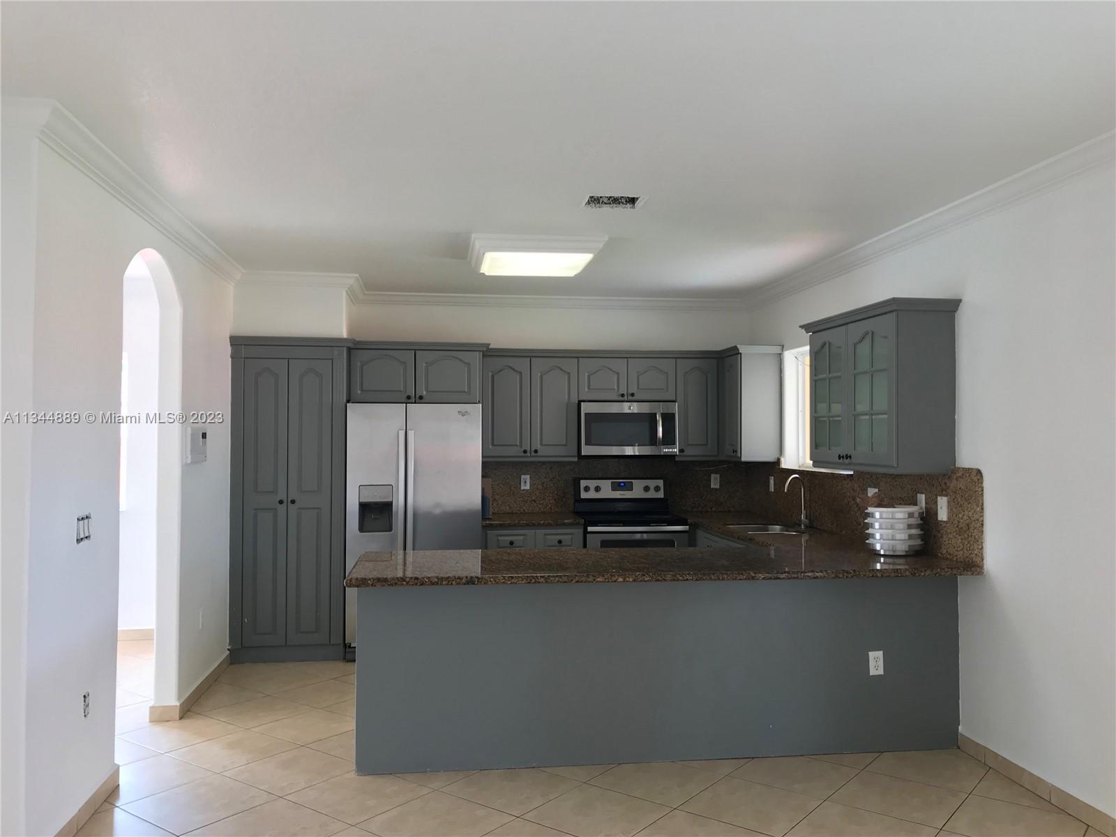16057 Southwest 53rd Terrace Miami, FL 33185 - Photo 12 of 30 a kitchen with stainless steel appliances a refrigerator and a stove
