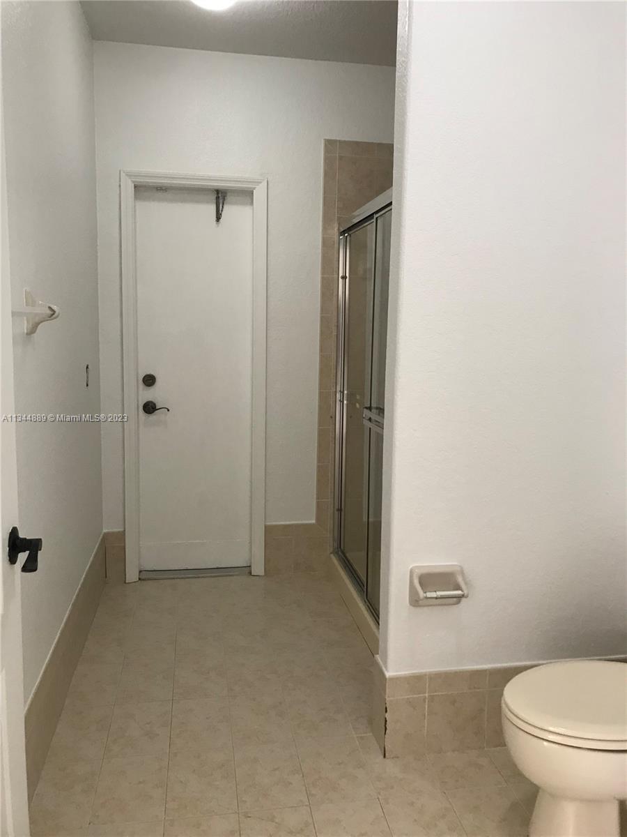 16057 Southwest 53rd Terrace Miami, FL 33185 - Photo 14 of 30 a bathroom with a granite countertop toilet and a shower