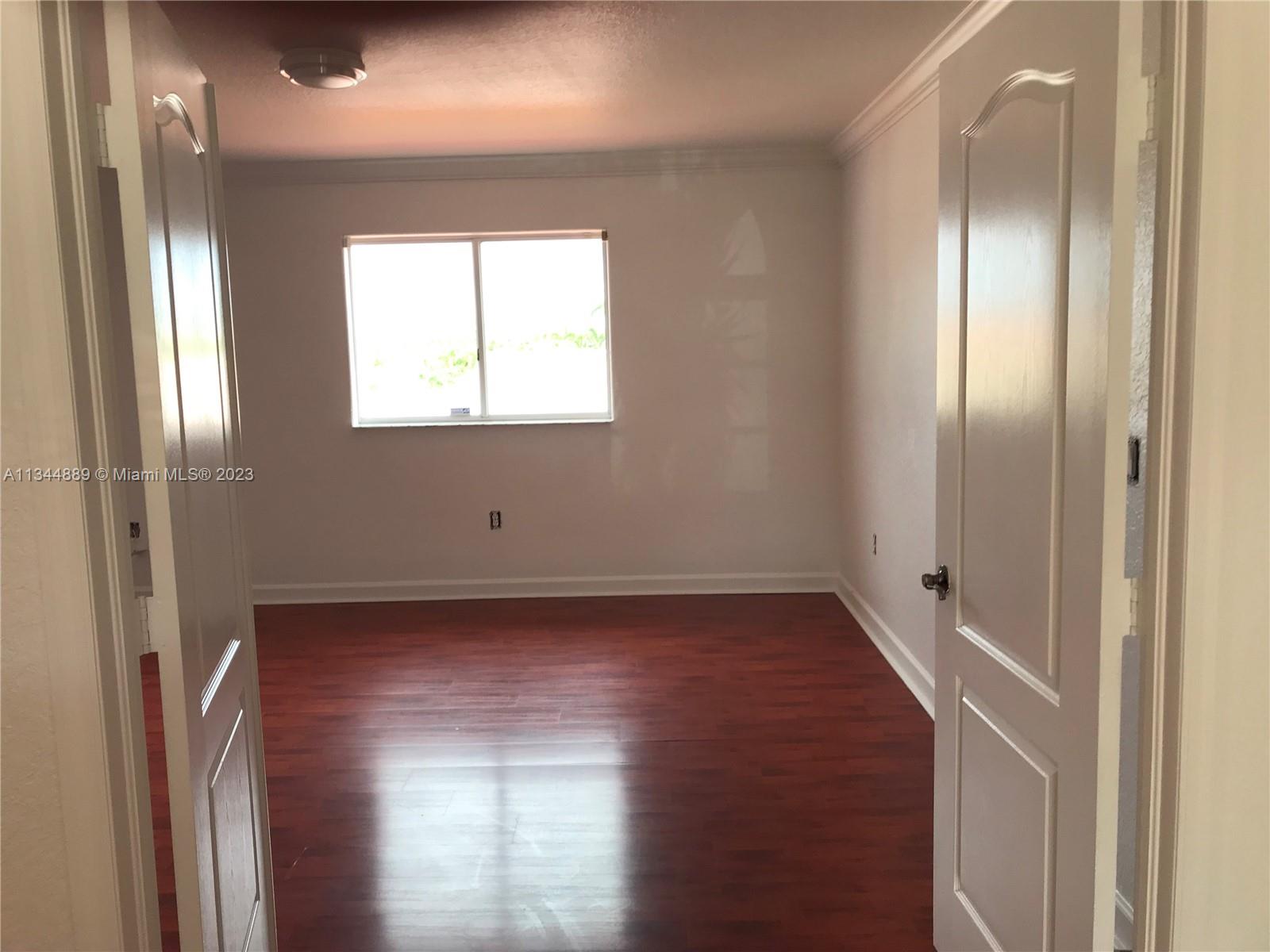 16057 Southwest 53rd Terrace Miami, FL 33185 - Photo 21 of 30 a view of a hallway with wooden floor and a large window