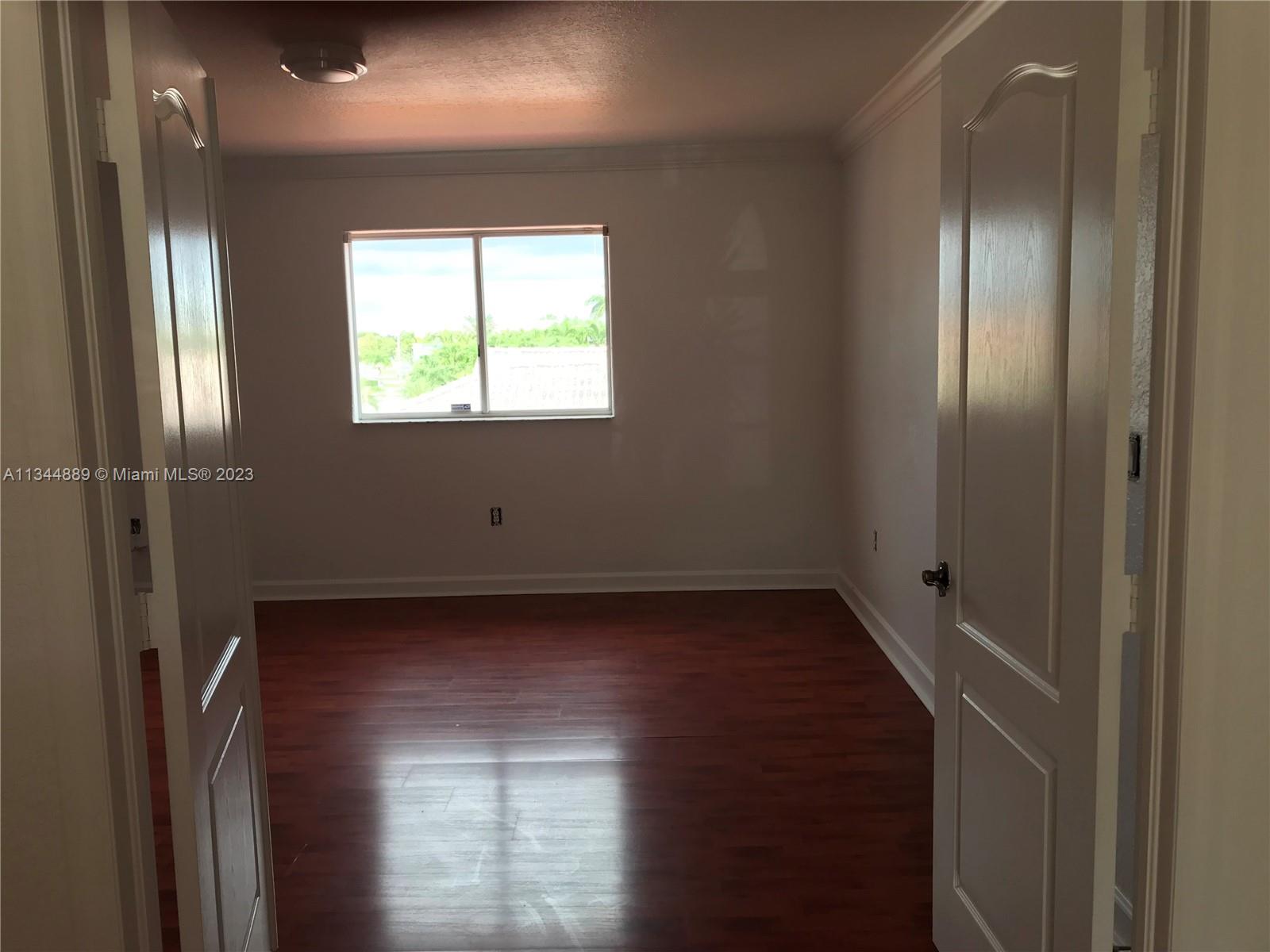 16057 Southwest 53rd Terrace Miami, FL 33185 - Photo 22 of 30 a view of an empty room with wooden floor and a window
