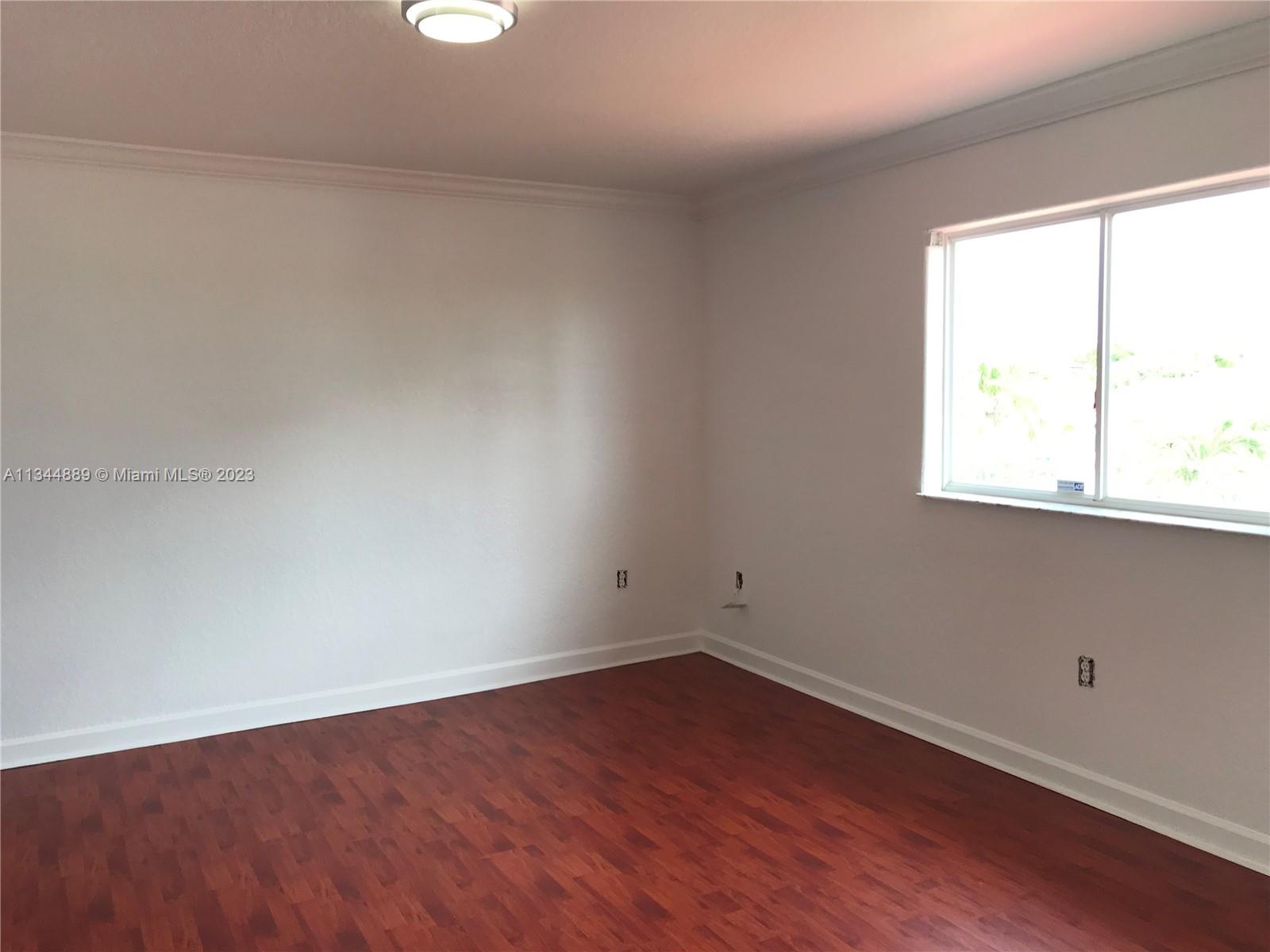 16057 Southwest 53rd Terrace Miami, FL 33185 - Photo 23 of 30 an empty room with wooden floor and windows