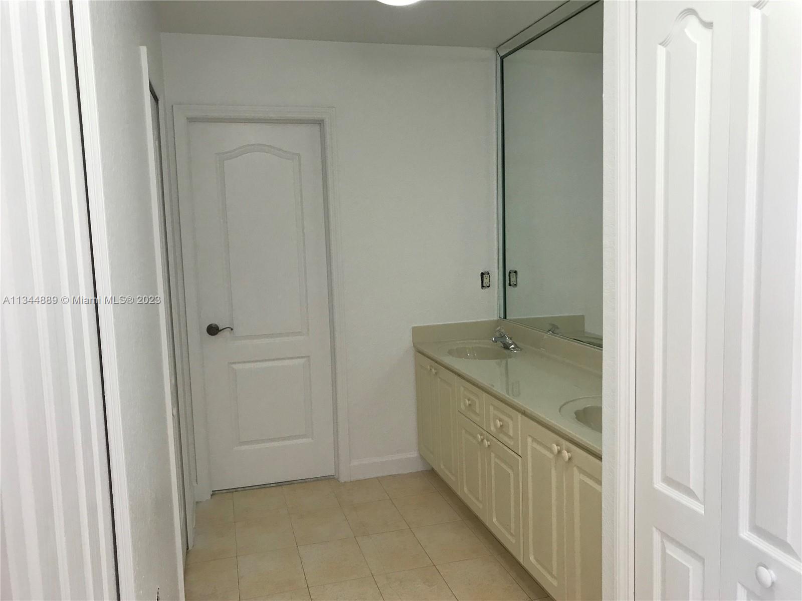16057 Southwest 53rd Terrace Miami, FL 33185 - Photo 25 of 30 a bathroom with a granite countertop sink a mirror and a bathtub