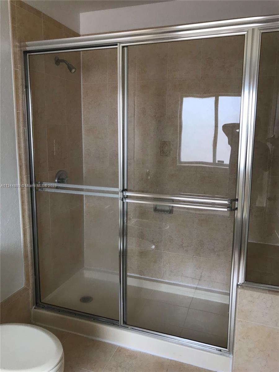16057 Southwest 53rd Terrace Miami, FL 33185 - Photo 27 of 30 a bathroom with a glass shower door