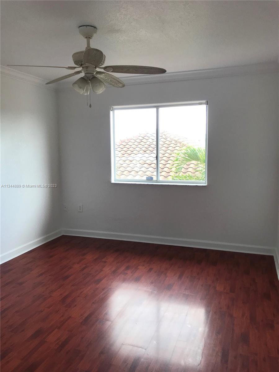 16057 Southwest 53rd Terrace Miami, FL 33185 - Photo 28 of 30 an empty room with wooden floor fan and windows
