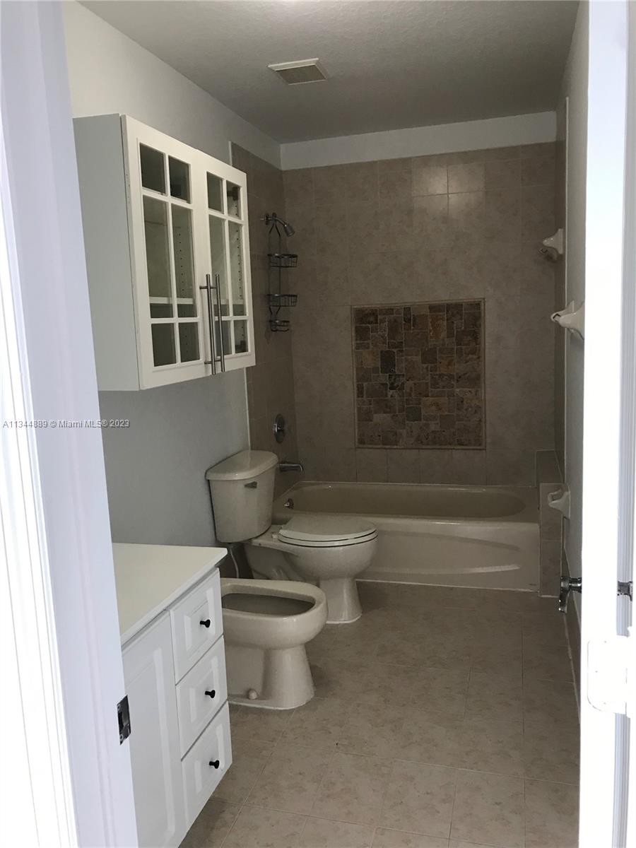 16057 Southwest 53rd Terrace Miami, FL 33185 - Photo 30 of 30 a bathroom with a granite countertop toilet a sink and a bathtub
