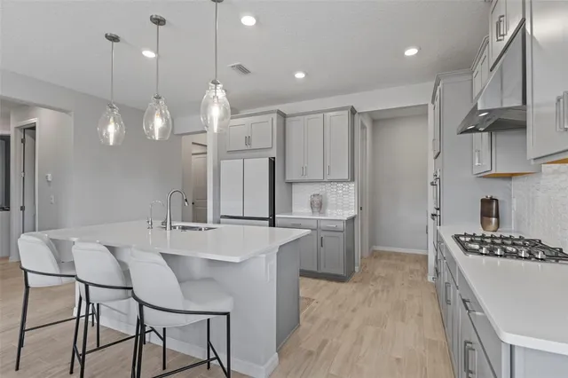 a kitchen with kitchen island granite countertop a sink cabinets and stainless steel appliances