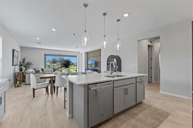 a kitchen with center island a sink stainless steel appliances and dining table