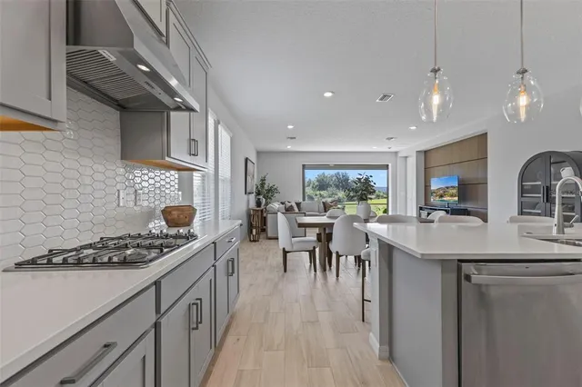 a kitchen with a sink a stove and chairs