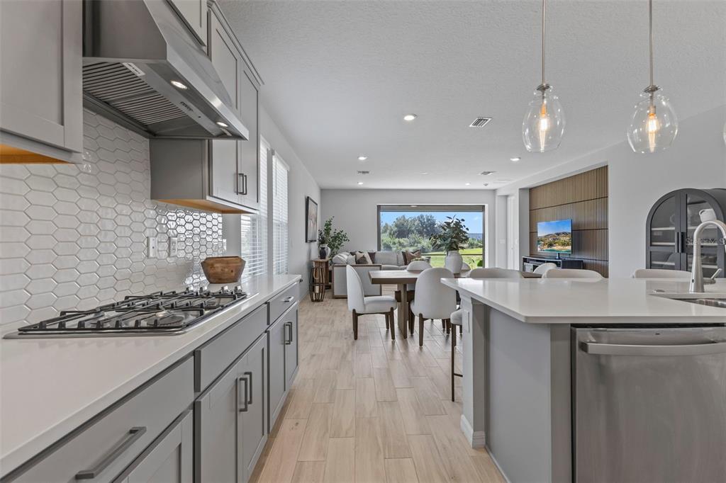 5679 Blue Reef Place Nokomis, FL 34275 - Photo 16 of 46 a kitchen with a sink a stove and chairs