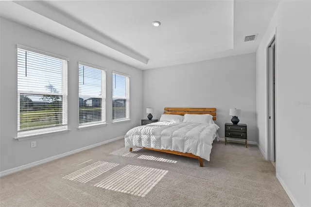 a bedroom with a bed and a large window