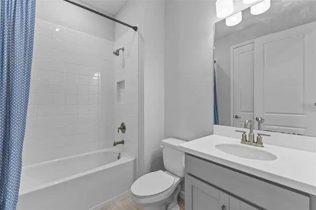 a bathroom with a sink toilet vanity and shower