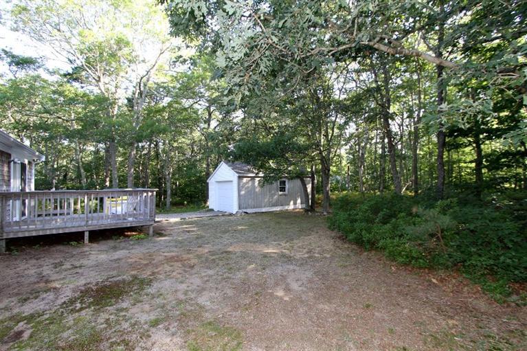 77 Sheffield Road Brewster, MA 02631 - Photo 24 of 26 a view of a wooden deck with a big yard and large trees